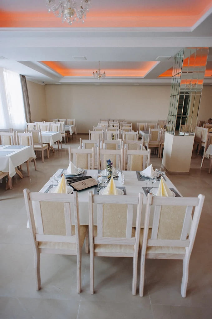 Бенкетний зал Lovelia з теплою помаранчевою підсвіткою стелі та кришталевими люстрами