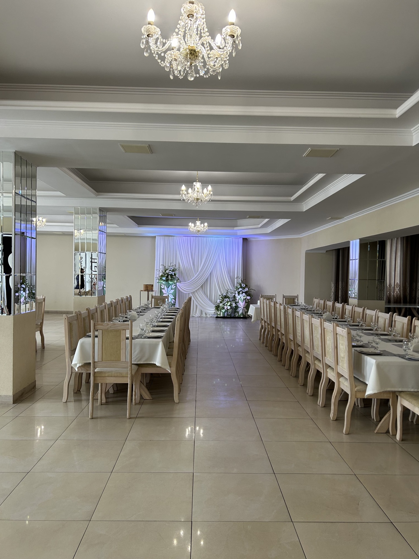 Весільний бенкетний зал Lovelia з білими драпіровками та кришталевими люстрами